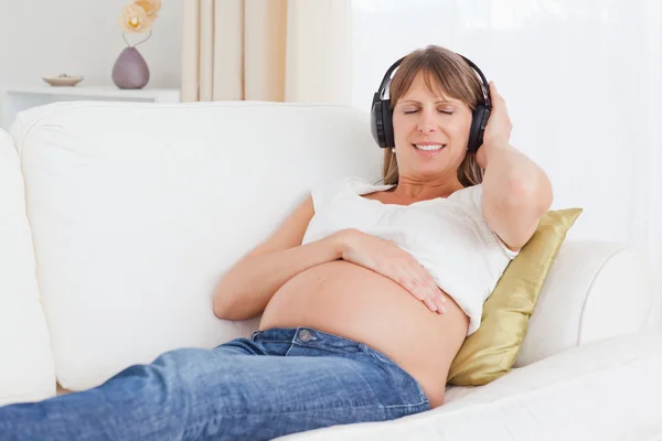 Felice donna incinta ascoltando musica — Foto Stock