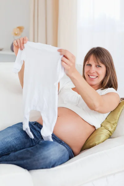 Dobře vypadající těhotná žena, držící dítě roste vleže na — Stock fotografie