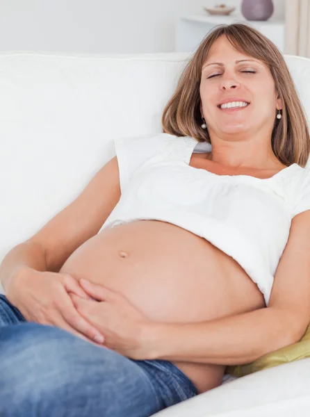 Encantadora mujer embarazada posando mientras miente —  Fotos de Stock