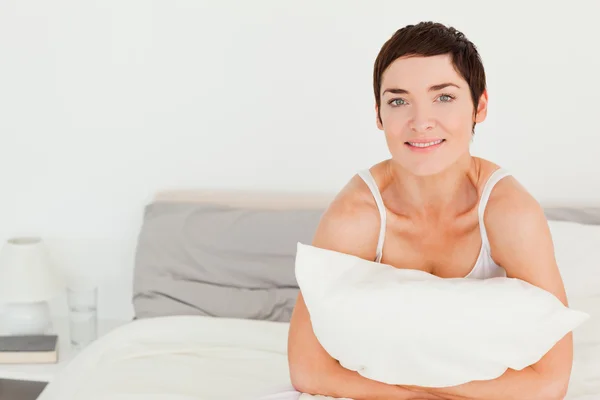 Mujer joven sosteniendo una almohada —  Fotos de Stock