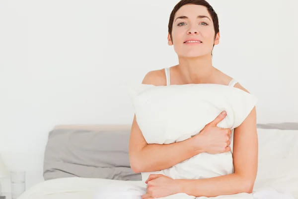 Charming woman holding a pillow — Stock Photo, Image