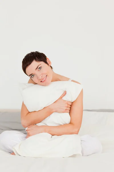 一个可爱的女人抱着一个枕头的肖像 — 图库照片