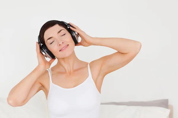 Entzückte Frau hört Musik — Stockfoto