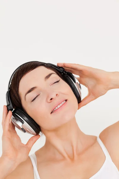 Portrait d'une brune enchantée écoutant de la musique — Photo