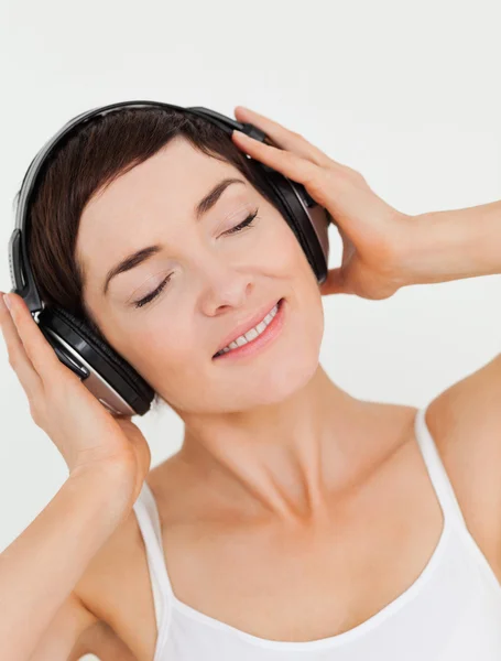 Porträtt av en charmig brunett som lyssnar på musik — Stockfoto
