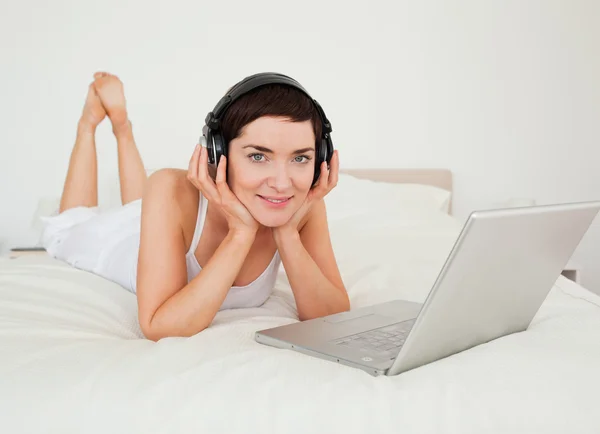 Kvinna lyssna på musik med sin laptop — Stockfoto