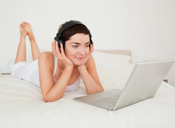 Jovem mulher ouvindo música com seu laptop — Fotografia de Stock