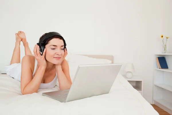 Ung kvinna tittar på en film med sin laptop — Stockfoto