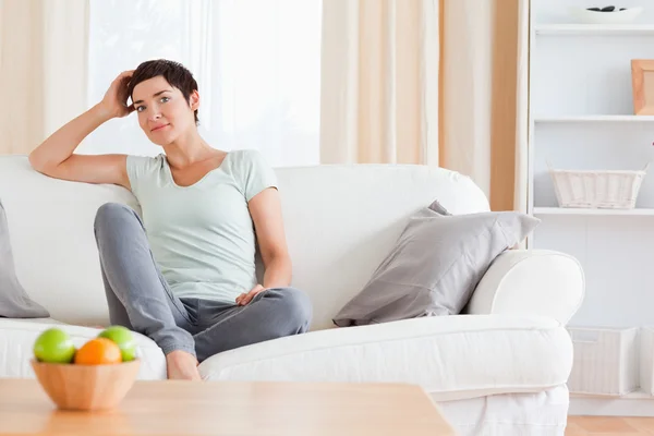 Lovely woman sitting on a sofa — Stock Photo, Image
