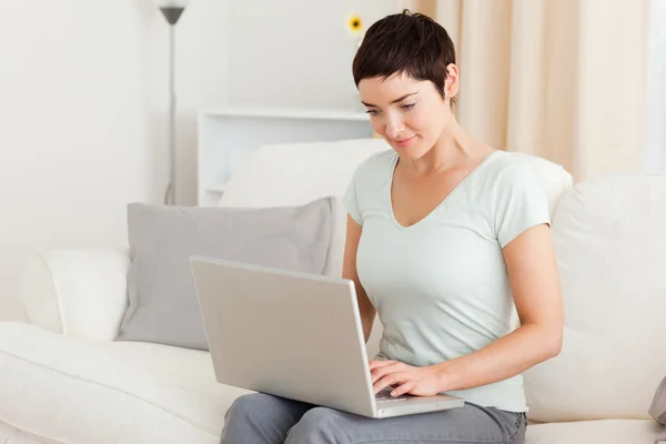 Jonge vrouw die met een laptop werkt — Stockfoto