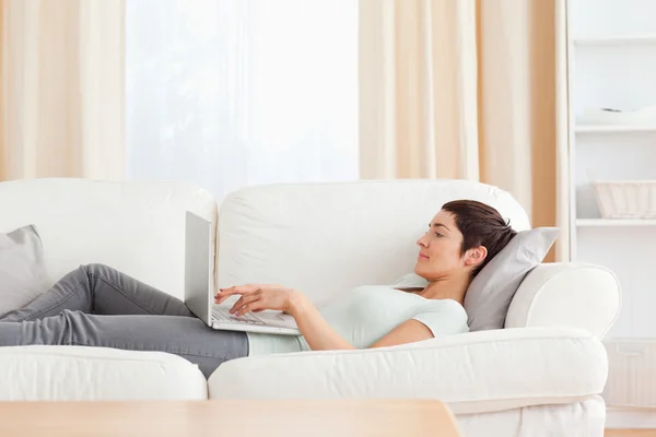 Молодая женщина расслабляется с ноутбуком — стоковое фото