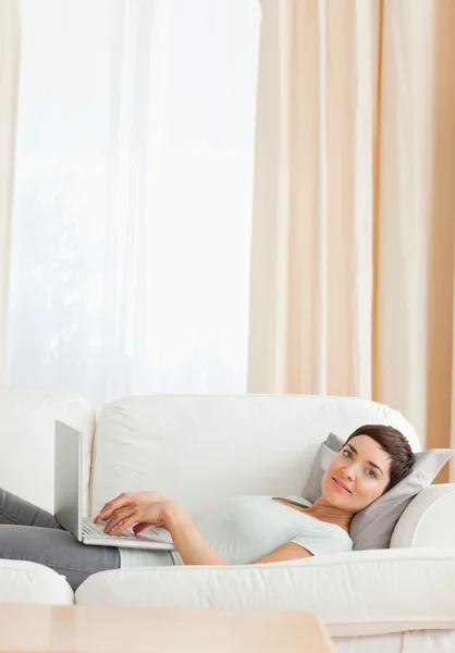 Bir dizüstü bilgisayar ile dinlendirici bir kadın portresi — Stok fotoğraf