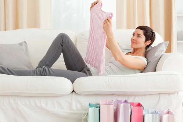 Woman looking at a T-shirt she just bought — Stock Photo, Image