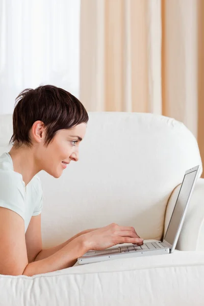 Retrato de uma mulher bonita de cabelos curtos usando um laptop — Fotografia de Stock