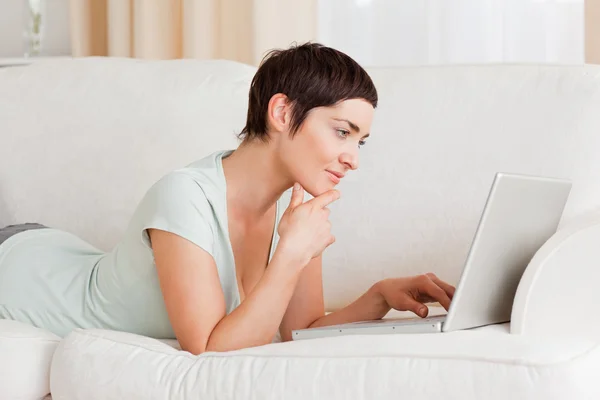 Focada mulher de cabelos curtos usando um laptop — Fotografia de Stock