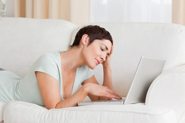 Mulher cansada usando um laptop — Fotografia de Stock