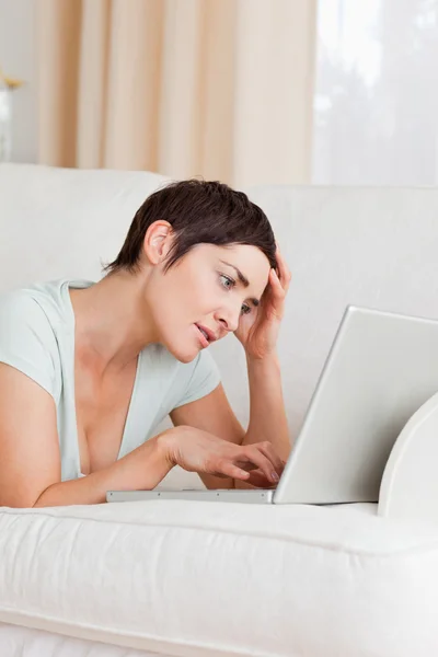 Zmęczony młoda kobieta za pomocą laptopa — Zdjęcie stockowe