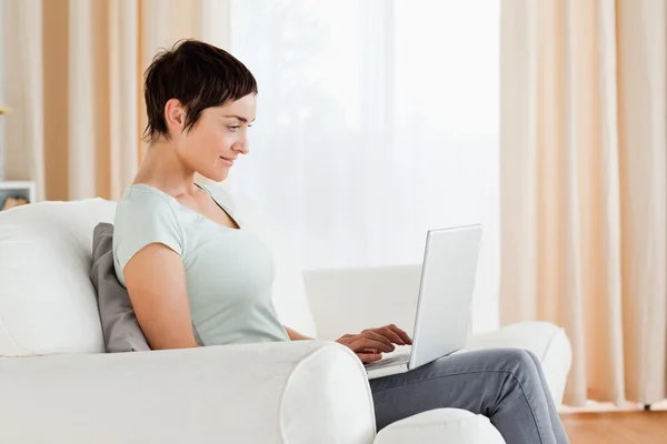 Mulher de cabelos curtos trabalhando com um laptop — Fotografia de Stock