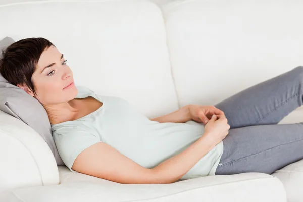 Woman lying on a couch — Stock Photo, Image
