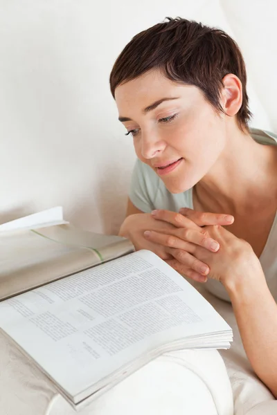 Portrait of a smiling woman reading a magazine — Stock Photo, Image