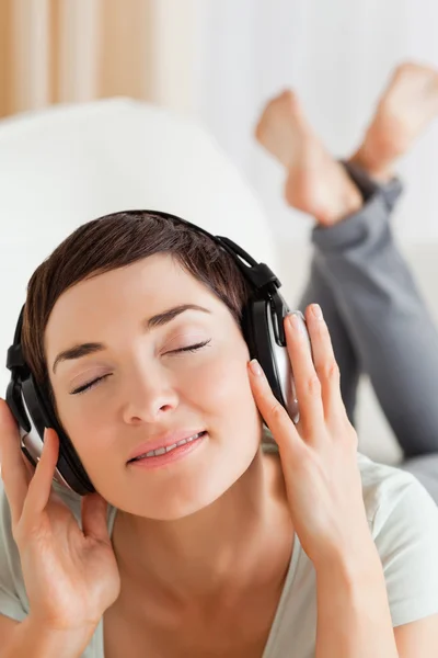 Retrato de uma morena encantadora ouvindo música — Fotografia de Stock