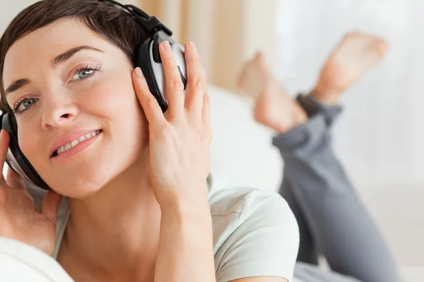 Primo piano di una bruna sorridente che ascolta musica — Foto Stock