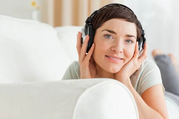 Närbild på en korthårig brunett som lyssnar på musik — Stockfoto