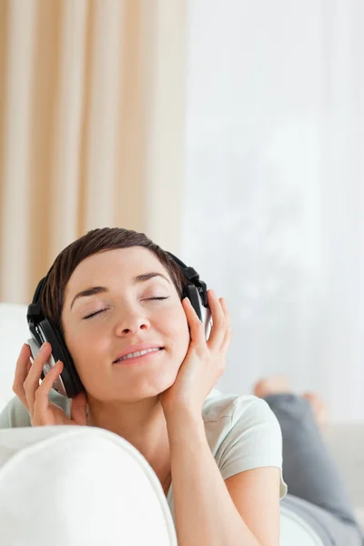 Portrait of a short-haired brunette listening to music — Stock Photo, Image