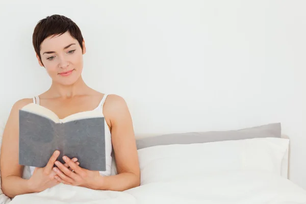 Närbild på en brunett som läser en bok — Stockfoto