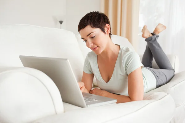 Sorridente donna dai capelli corti utilizzando un computer portatile — Foto Stock