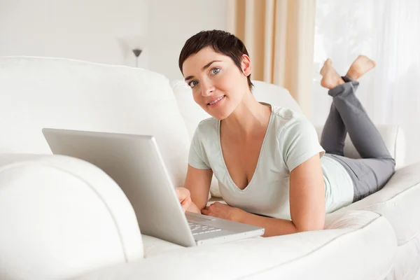 Sorrindo mulher de cabelos curtos com um laptop — Fotografia de Stock