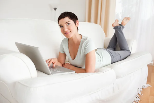 Glad korthårig kvinna med en bärbar dator — Stockfoto