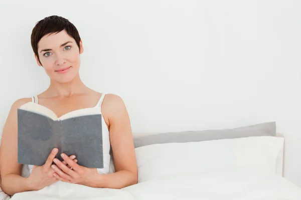 Närbild på en brunett som håller en bok — Stockfoto