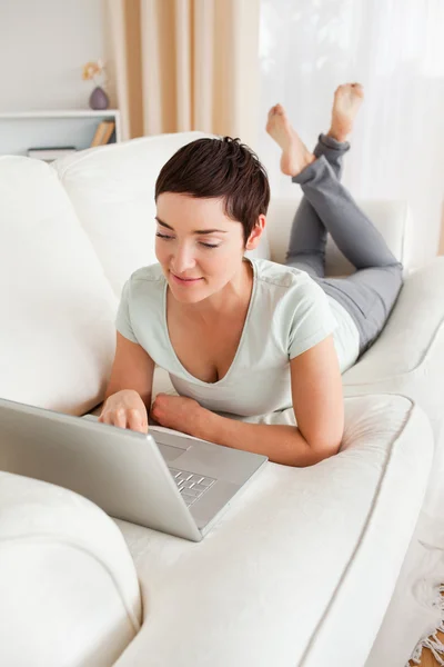 Portrait of a dark-haired woman using a laptop — Stock Photo, Image