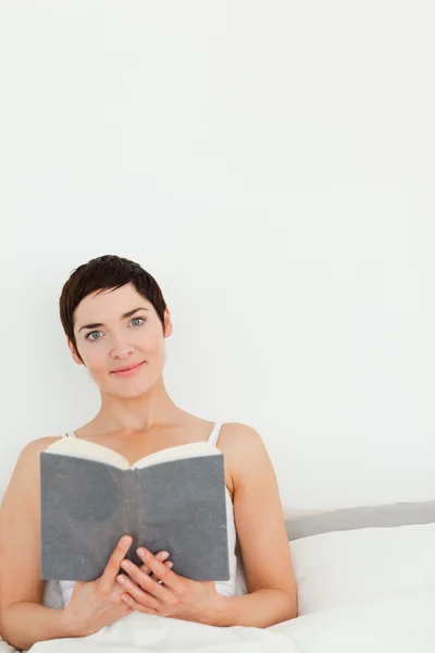 Porträtt av en brunett som håller en bok — Stockfoto