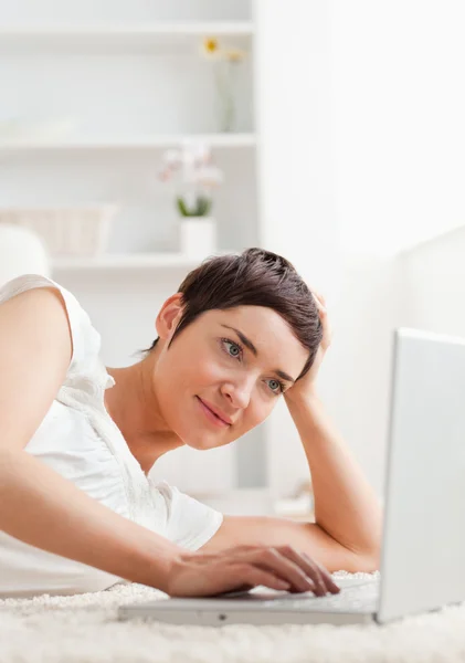 Retrato de uma mulher tranquila relaxando com um laptop — Fotografia de Stock