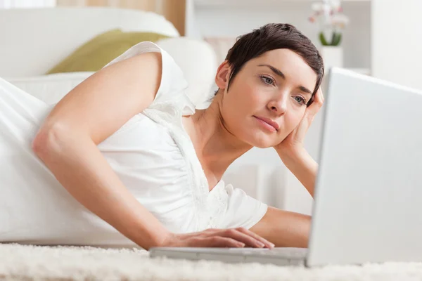 Закрыть серьезную женщину, расслабляющуюся с ноутбуком — стоковое фото