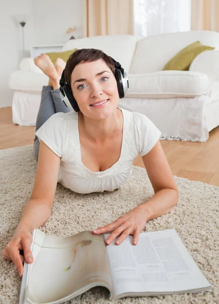 Retrato de una mujer con una revista disfrutando de algo de música — Foto de Stock