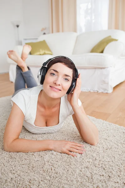 Ritratto di una bruna sorridente che ascolta musica — Foto Stock