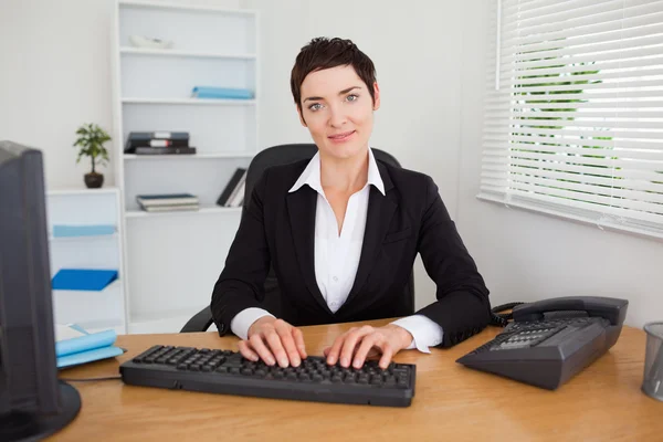 Lächelnde Sekretärin tippt auf ihr Keyboard — Stockfoto