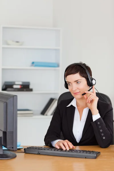 Retrato de uma secretária chamando com um fone de ouvido — Fotografia de Stock