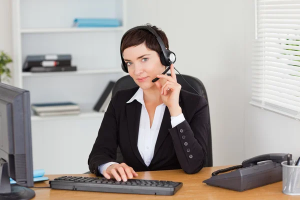 Ernstige secretaris belt met een headset — Stockfoto