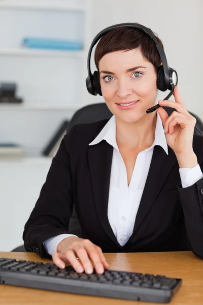 Retrato de una secretaria seria llamando con un auricular — Foto de Stock