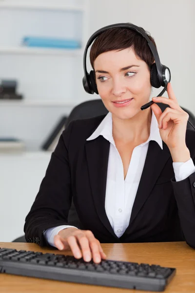 Retrato de uma secretária profissional chamando com um fone de ouvido — Fotografia de Stock