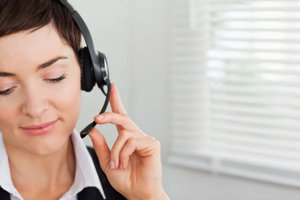 Fechar de um secretário focado chamando com um fone de ouvido — Fotografia de Stock