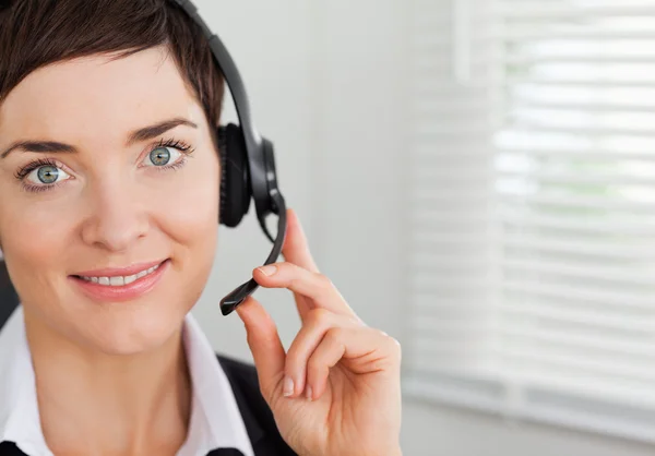 Primer plano de una secretaria sonriente llamando con un auricular —  Fotos de Stock