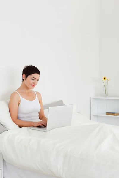 Good looking brunette using a laptop — Stock Photo, Image