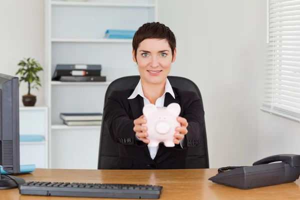 Office worker holding a piggybank — Stock Photo, Image