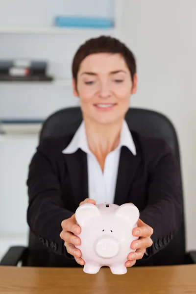 Portrait of an office worker holding a piggybank — Stock Photo, Image