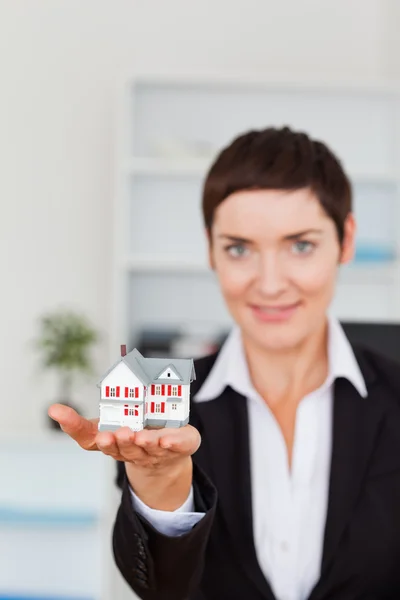 Portrait of a woman showing a house miniature — Stock Photo, Image